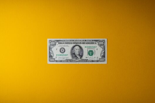 Close-up of a $100 bill on a yellow background