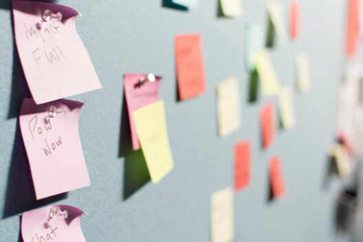 Colorful sticky notes on a blue bulletin board