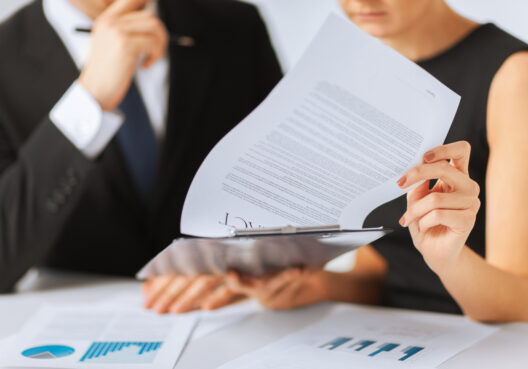Business professionals reviewing documents and charts in an office setting